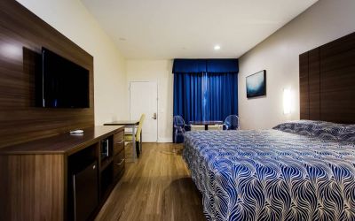 Day use room with dining table, work desk and TV at Palace Inn Blue Gessner.