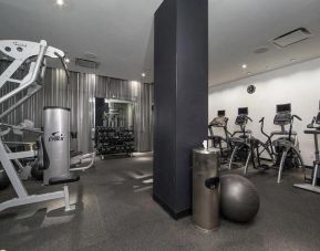 The NoMo Soho’s fitness center, with racked weights and various exercise equipment.