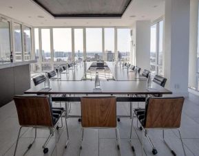 One of the hotel meeting rooms, with over a dozen seats arranged around long tables, and panoramic city views.