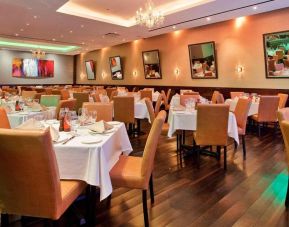 Empire Steak House, the hotel’s on-site restaurant, with small tables and hard floor.