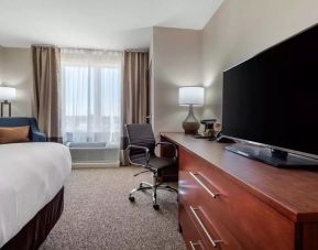 Delux king bed with TV and business desk at Comfort Inn & Suites Napanee.