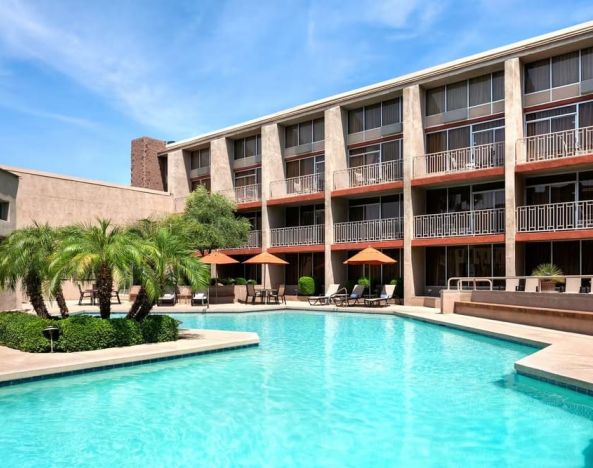 Lovely outdoor pool with sun beds and umbrellas at Wyndham Phoenix Airport/Tempe.