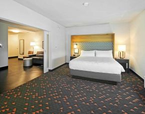 Spacious king bed with lounge area at Holiday Inn & Suites Calgary Airport North.