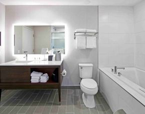 Private guest bathroom with bath and shower combo at Holiday Inn & Suites Calgary Airport North.