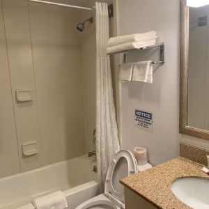Guest bathroom with shower and tub at Sky Hotel Flushing - Laguardia Airport.