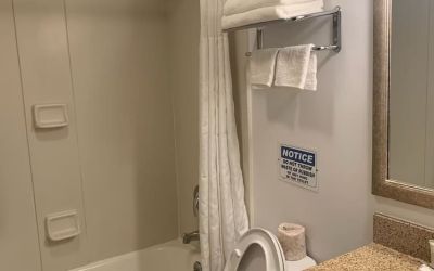 Guest bathroom with shower and tub at Sky Hotel Flushing - Laguardia Airport.