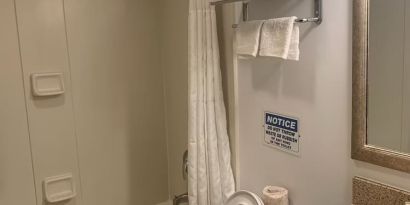 Guest bathroom with shower and tub at Sky Hotel Flushing - Laguardia Airport.