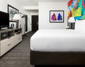 Spacious king bedroom with TV and natural light at Hotel Studio Allston.