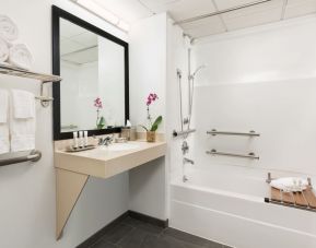Private guest bathroom with bath and shower at Hotel Studio Allston.