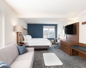 King bed with TV and business desk at Holiday Inn Express & Suites Boston-Cambridge.