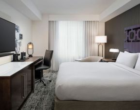 Delux king room with TV, desk, and natural light at Courtyard San Diego Downtown.
