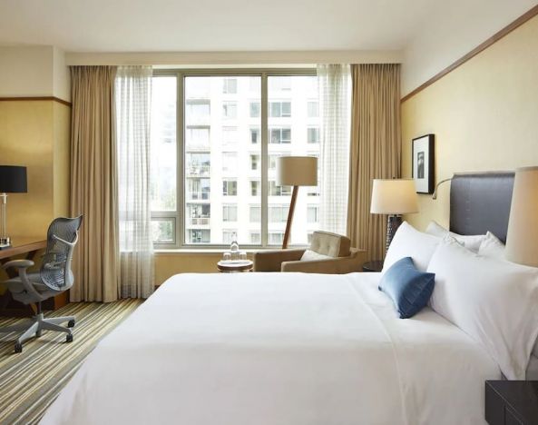 King bedroom with business desk and natural light at Pan Pacific Seattle.