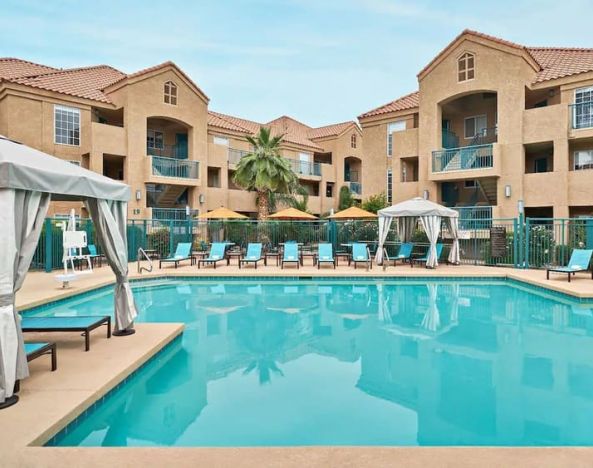Lovely outdoor pool with cabanas and pool chairs at Hyatt House Scottsdale.