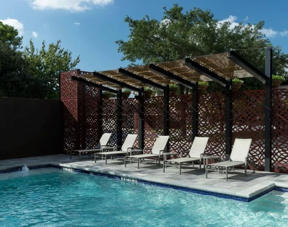 Stunning outdoor pool with pool chairs at Courtyard By Marriott Houston Heights/I-10.
