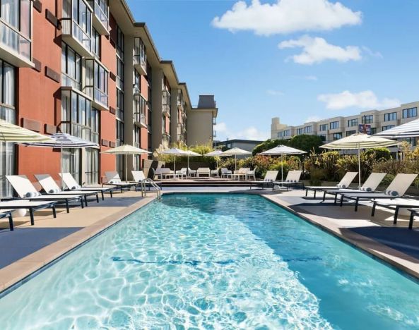 Stunning outdoor pool with sun beds and umbrellas at Hotel Caza.