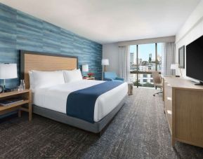 King bedroom with lots of natural light and work desk at Hotel Caza.