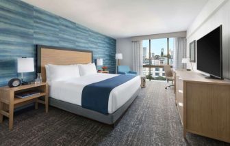 King bedroom with lots of natural light and work desk at Hotel Caza.