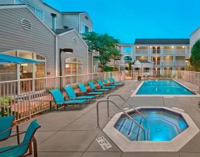 Outdoor pool with lounge chairs at Residence Inn Boston Tewksbury.
