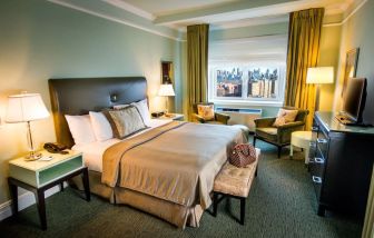 King bed with TV and work desk at Beacon Hotel.