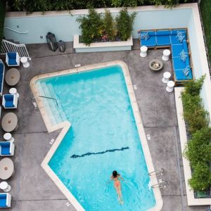 Refreshing outdoor pool surrounded by sun loungers at Maison 140 Beverly Hills.
