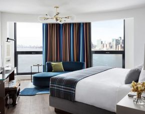 Spacious king bed with TV and seating area at Graduate New York.