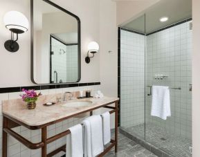 Private guest bathroom with shower at The Candler Hotel Atlanta, Curio Collection By Hilton.