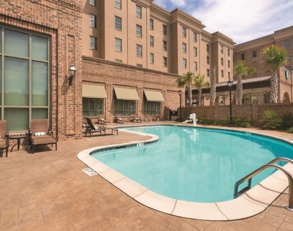 Outdoor pool with pool chairs at Embassy Suites By Hilton Savannah.