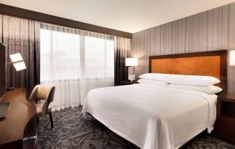 Delux king room with TV and work desk at Embassy Suites By Hilton Santa Clara Silicon Valley.