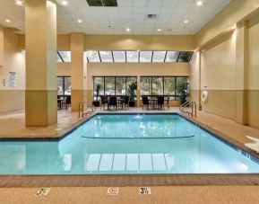Relaxing indoor pool with seating area at Embassy Suites By Hilton Santa Clara Silicon Valley.