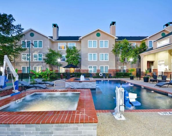 Luxurious pool area with jacuzzi hot tub at Homewood Suites By Hilton Dallas-Lewisville.