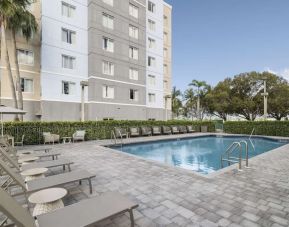 Relaxing pool area with pool chairs at Homewood Suites By Hilton Miami Airport-Blue Lagoon.
