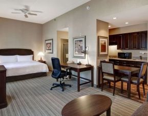 Spacious king bed with business desk at Homewood Suites By Hilton Burlington.