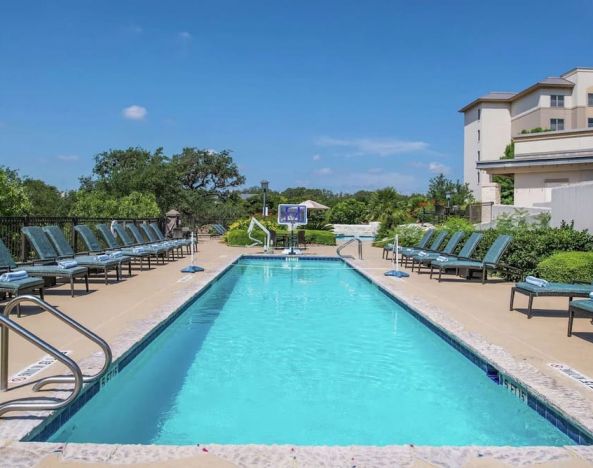Stunning outdoor pool with pool chairs at Hilton San Antonio Hill Country.