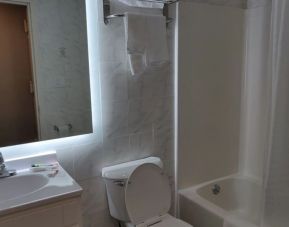 Guest bathroom with shower and bath at Hotel Key.