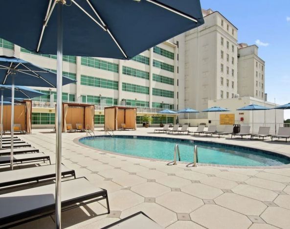 Stunning outdoor pool with pool chairs at Hilton Baton Rouge Capitol Center.