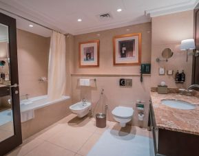 Guest bathroom with shower and bath at Millennium Hotel Doha.