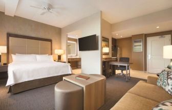 King bed with natural light at Homewood Suites By Hilton Calgary Downtown.