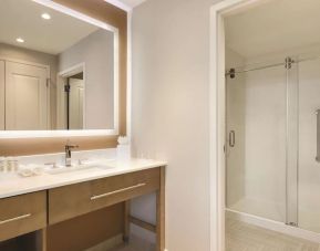 Guest bathroom with shower at Homewood Suites By Hilton Calgary Downtown.