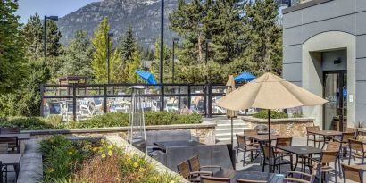 Outdoor terrace set in a lovely garden at Hilton Whistler Resort & Spa.
