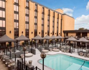 Relaxing pool area with cabanas and pool chairs at Wyndham Garden Dallas North.