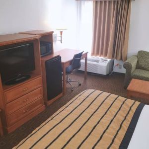 Sofa, work desk and TV inside day use room of the Coratel Inn & Suites By Jasper New Braunfels IH-35 EXT 189.