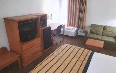 Sofa, work desk and TV inside day use room of the Coratel Inn & Suites By Jasper New Braunfels IH-35 EXT 189.