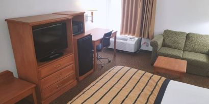 Sofa, work desk and TV inside day use room of the Coratel Inn & Suites By Jasper New Braunfels IH-35 EXT 189.