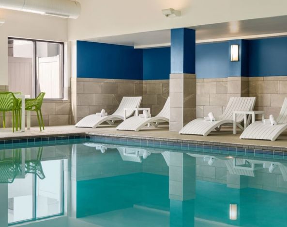 The hotel’s large indoor swimming pool, with surrounding chairs and loungers.