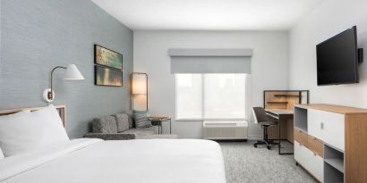 Bright-lit day use room with work desk and sofa at TownePlace Suites Nashville Midtown.