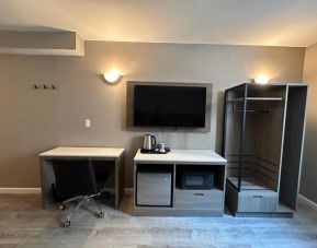 Dayroom with TV, mini-fridge, and work space at Regal Inn & Suites New York.