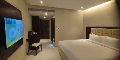 King bed with TV at Mayur Belgaum Presidency Hotel & Spa.