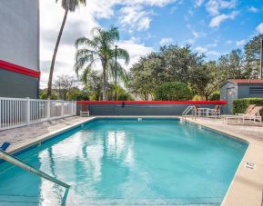 Outdoor pool with seating area at OYO Townhouse Orlando West.