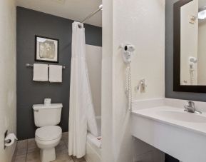 Private bathroom with shower at OYO Townhouse Orlando West.