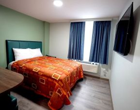 King bed with natural light at Hotel Liberty Inn & Suites.